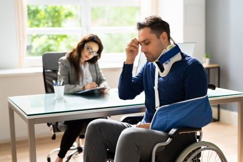 injured man in wheelchair meeting with a personal injury lawyer in Detroit, MI