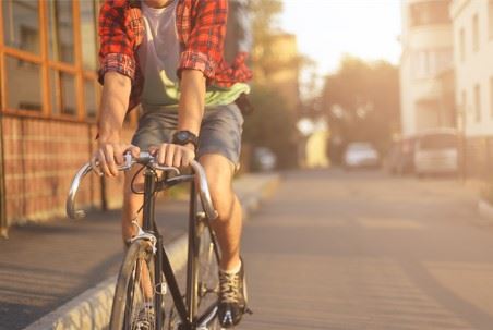 man riding his bicycle on the side of the street