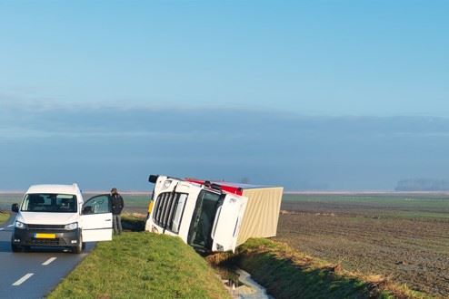 overturned truck on the side of the road