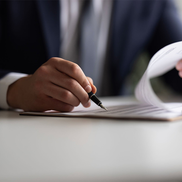 BGLaw_circle_3_2148320626 A business man is writing on a piece of paper