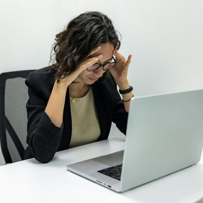 A young woman is stressed looking at her laptop